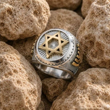 Silver and gold ring with star design on rocks
