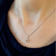 Tiny 14K gold diamond Star of David necklace worn by woman