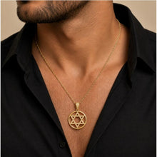 Gold necklace with a Star of David pendant worn by a person in a black shirt.